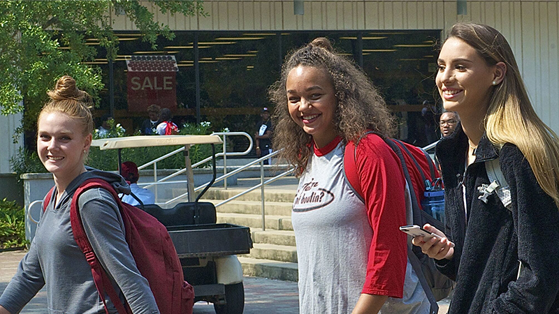 Two female studnets walking on campus