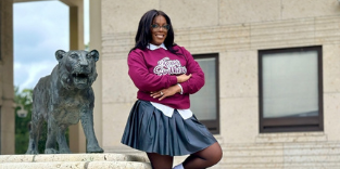 woman posing in front of school